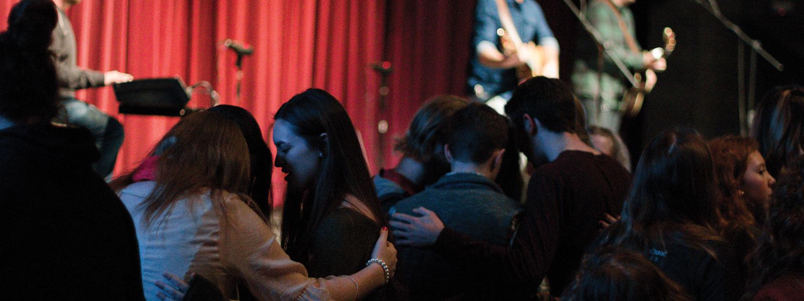 three guitarists and drummer leading worship in chapel service